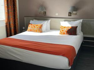 Postel nebo postele na pokoji v ubytování Cit'Hotel Le Louvre Orange