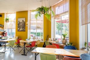 a restaurant with tables and chairs and windows at Boutique Hotel Joure - centrum & haven in Joure +64 photos
