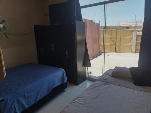 a bedroom with a bed and a large window at Casa Amoblada de Verano Inclán Mollendo Arequipa in Mollendo