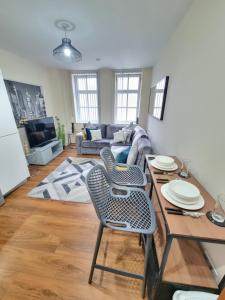 a living room with a table and a couch at Modern 2BR Flat in Bradford City Centre! in Bradford +23 photos