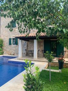 a house with a swimming pool next to a building at Villa Piedmont in Karojba