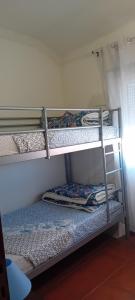 a couple of bunk beds in a room at Caminho da Vila moradia. in Escalos de Cima
