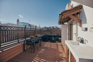 a patio with a table and chairs on a balcony at Sant’Andrea Penthouse by Montenapoleone Living in Milan