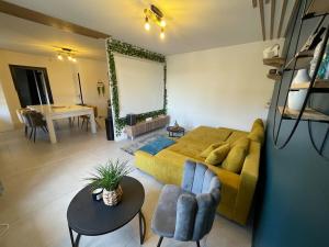 a living room with a yellow couch and a table at Cinema et Billiard in Charnay-lès-Mâcon