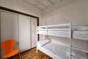 a bedroom with two bunk beds and a orange chair at F3 house with garden in Grosbreuil in Grosbreuil +5 photos