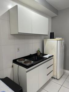 a kitchen with a stove and a refrigerator at 2 Quartos amplos Completo com Internet Garagem e Ar condicionado in Paranaguá