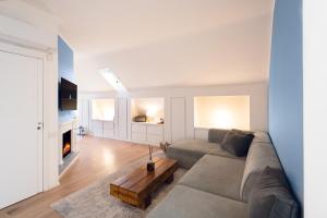 a living room with a couch and a fireplace at Sant’Andrea Penthouse by Montenapoleone Living in Milan +17 photos