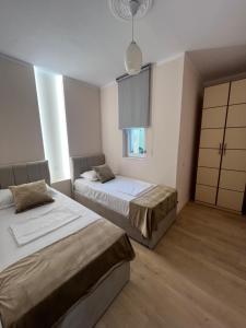 a bedroom with two beds and a window at Bellavista Qerret Apartments in Golem +88 photos