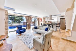 a living room with a couch and chairs and a kitchen at Serin Villas in İslâmlar