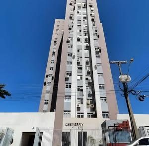 Un edificio alto con un cielo azul al fondo. en Apartamento Confortavel para 5 hospede e Ar, en Foz do Iguaçu