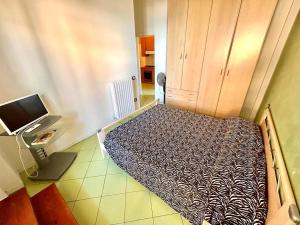 a bed in a room with a desk and a computer monitor at MARZIO - appartamenti con terrazzo, posto auto e spiaggia in Marcelli