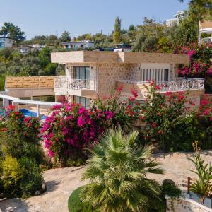 a house with a lot of flowers in front of it at Serin Villas in İslâmlar