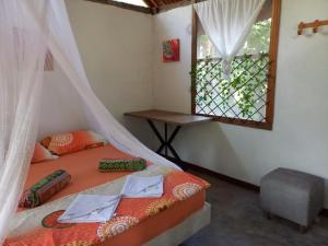 una camera con un letto con una finestra e un tavolo di Camping Zona A dentro del PNN Tayrona a Santa Marta