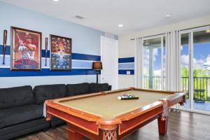 a living room with a pool table and a couch at Extravagant Home With Movie Theater, Private Pool And Waterpark & Resort Access At Encore Resort - 241Fl in Kissimmee