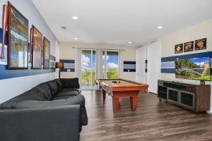 a living room with a couch and a pool table at Extravagant Home With Movie Theater, Private Pool And Waterpark & Resort Access At Encore Resort - 241Fl in Kissimmee