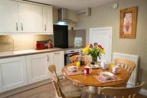 a kitchen with a wooden table with chairs and a dining room at Bramwood Cottages in Pickering +13 photos