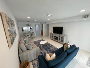 a living room with a blue couch and a tv at Sunny Jupiter Villa in Jupiter