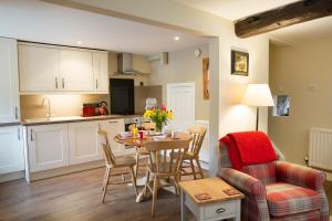 a kitchen and living room with a table and chairs at Bramwood Cottages in Pickering