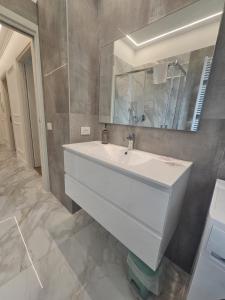 サンレモにあるSanremo Prestige Apartmentの白い洗面台と鏡のあるバスルーム
