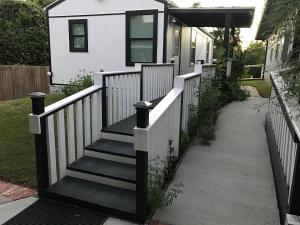 a house with a white fence and a staircase at Cozy Cabin in Brazoria