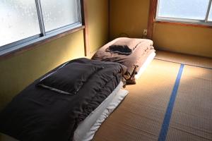 Fukuroi民泊二七 一棟貸し WiFi完備 袋井駅周辺 敷地内無料駐車場有的带2扇窗户的客房内的2张单人床