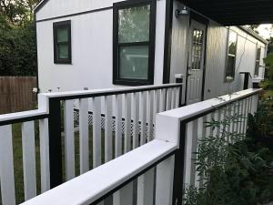 a white house with a black and white fence at Cozy Cabin in Brazoria +8 photos