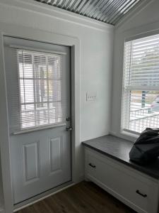 a white room with a door and a window at Cozy Cabin in Brazoria