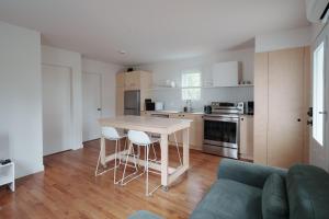 Una cocina y una sala de estar con una mesa y un sofá. en Chalets OST Shefford FORFAIT GROUPE, en Shefford