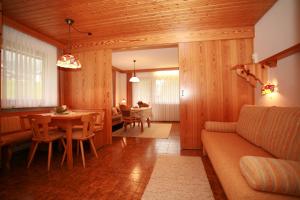 a living room with a couch and a table and chairs at Gästehaus Etschmann in Riezlern