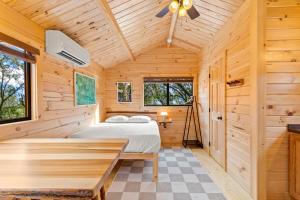 a bedroom in a wooden cabin with a bed and a table at Happy Travelers RV Resort in Thonotosassa +28 photos