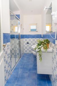 bagno piastrellato blu con lavandino e doccia di Casa Gradoni Anema e Core - De Vivo Realty a Meta Altre 13 foto