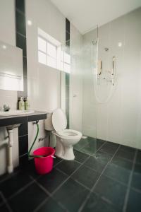 y baño con aseo, ducha y cubo. en Dyra Homestay in Lumut, en Lumut