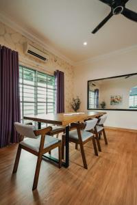 Un comedor con mesa y sillas de madera. en Dyra Homestay in Lumut, en Lumut 98 fotos más