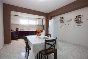 a kitchen with a table with chairs and a refrigerator at Natural Quiet Accommodation 2 - Faliraki in Kalithies