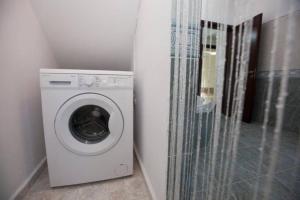 a washer and dryer in a corner of a room at Natural Quiet Accommodation 2 - Faliraki in Kalithies