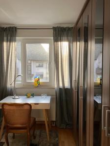 a room with a desk and a window and a table at Stilvolle 3,5-Zimmer-Wohnung in Ilvesheim in Ilvesheim