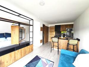 a bedroom with a bed and a kitchen in a room at Apartaestudio Moderno Miró in Cali
