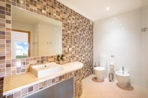 a bathroom with a sink and a toilet at NAU Salema Beach Village in Salema