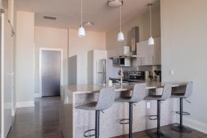 a kitchen with a counter and stools in it at Downtown Luxury 2BR Loft in Milwaukee