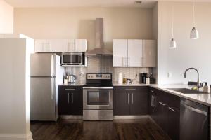 a kitchen with white cabinets and stainless steel appliances at Downtown Luxury 2BR Loft in Milwaukee