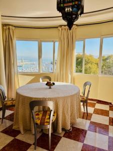 a dining room with a table and chairs and windows at Ventana al mar , Tánger in Tangier +23 photos