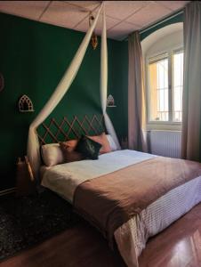 a woman laying on a bed in a green bedroom at Atlas room with shared bathroom in Bratislava