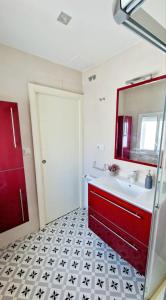 a bathroom with a red door and a white sink at Piso Mariña in Marín +18 photos