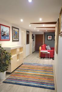 a living room with a red couch and a rug at Piso Mariña in Marín