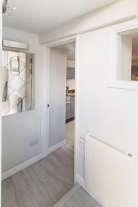 a hallway with white walls and a door at Gorgeous Boutique Flat Sleeps 2 in Lyme Regis in Lyme Regis