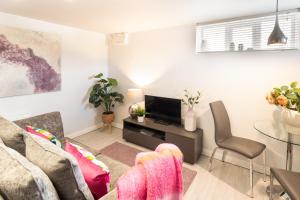 a living room with a couch and a tv at Gorgeous Boutique Flat Sleeps 2 in Lyme Regis in Lyme Regis