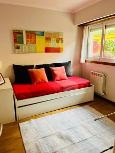 a bedroom with a bed with red sheets and a window at Apartamento en Comillas-Garden Apartment in Comillas in Comillas