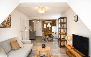 a living room with a couch and a tv at Amalie Genusskult in Speyer +6 photos
