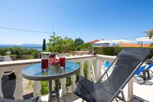 un tavolo su un balcone con 2 bevande di Ferienwohnung für 6 Personen ca 74 qm in Sveti Vid-Miholjice, Kvarner Bucht Krk a Sveti Vid-Miholjice