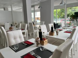 a dining room with white tables and white chairs at Hotel Sammaritani in Rimini